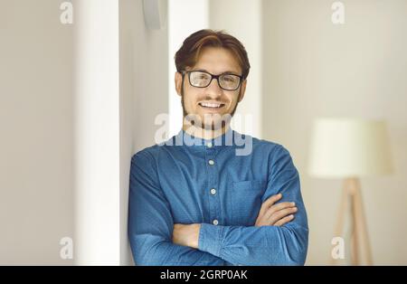 Porträt eines glücklichen und erfolgreichen jungen Geschäftsmannes, der mit selbstbewusster Ausdruckskraft die Kamera anschaut. Stockfoto