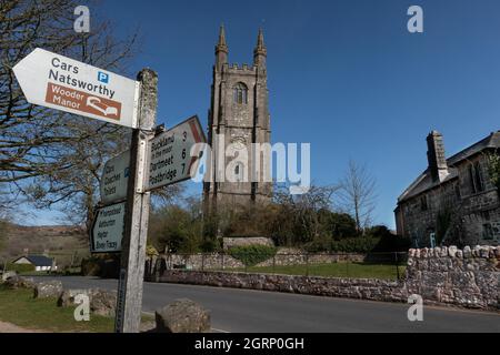 St Pancras Kirche und Wegweiser auf dem Dorfgrün bei Widecombe im Moor auf Dartmoor Devon England Stockfoto