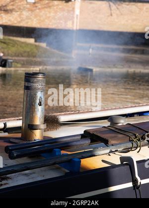 Nahaufnahme eines rauchenden Schornsteins auf einem schmalen Bootsdach Stockfoto