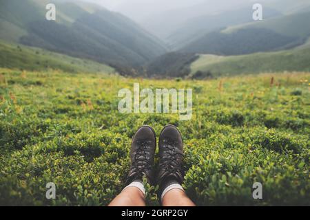 Stiefel von einsamen Touristen auf üppigen Heidelbeer Buschs bedeckten Berg. Landschaftsfotografie Stockfoto