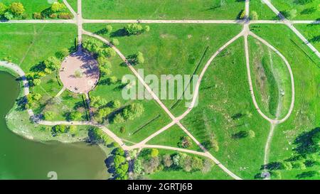 Fußgänger- und Radwege im leuchtend grünen Sommerpark. Luftpanorama Stockfoto