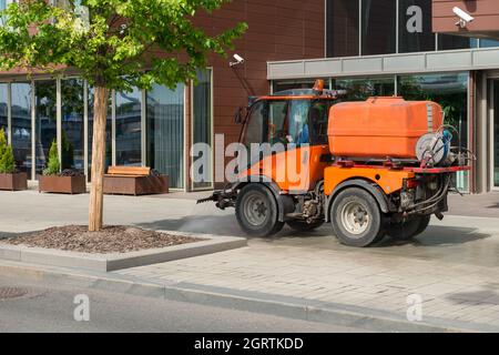 Kehrmaschine bei der Reinigung der Straße. Straßenreinigung und Waschen. Die Stadtverwaltung säubert die Stadt. Stockfoto