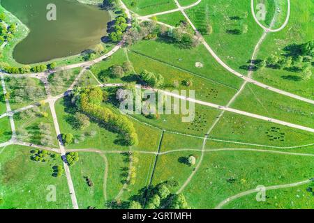 Fußgänger- und Radwege im leuchtend grünen Sommerpark. Ansicht von oben Stockfoto