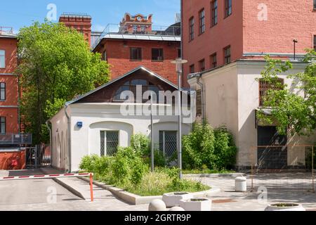Kleines einstöckiges Haus zwischen großen Industriegebäuden Stockfoto