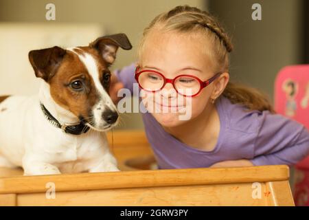 Schönes Mädchen mit einem Down-Syndrom mit ihrem Haustier Jack Russell Terrier Stockfoto