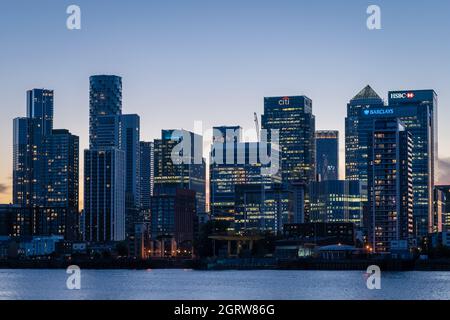 London, Großbritannien. Oktober 2021. UK Wetter: Canary Wharf Business Park Gebäude leuchten in der Dämmerung, wie von der Greenwich Peninsula gesehen. Kredit: Guy Corbishley/Alamy Live Nachrichten Stockfoto