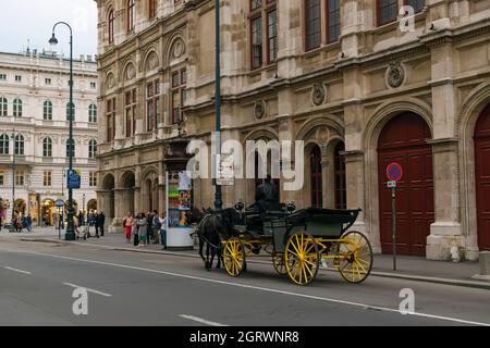 30 Mai 2019 Wien, Österreich - Pferdekutsche in der Straße bei der Wiener Staatsoper. Wolkiger Frühlingstag Stockfoto