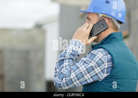 Porträt des männlichen Architekten, der im Freien auf dem Handy spricht Stockfoto
