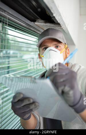 MTRA trägt Schutzmaske und überprüft die Produktion im Industriebetrieb Stockfoto