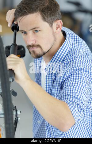 Der Mensch pumpt ein Rad Stockfoto