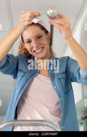 Frau hängend Gardinenstangen an der Decke Kante Stockfoto