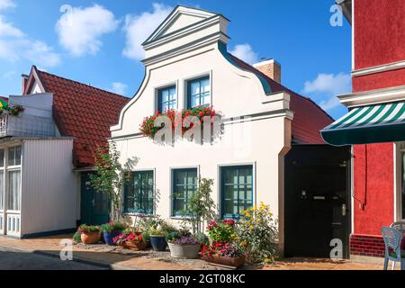 Ein typisches deutsches Dorfhaus mit Blumen vor der Fassade im historischen Zentrum von Warnemunde Rostock, einer Küstenstadt an der Ostsee. Stockfoto