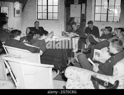 Squadron Leader B J E „Sandy“ Lane, der Kommandierende Offizier der RAF-Staffel Nr. 19 (mit Kamera gegenüber), entspannt sich mit einigen seiner Piloten im Squadron-Besatzungsraum auf der Manor Farm, Fowlmere, Cambridgeshire, September 1940. Stockfoto