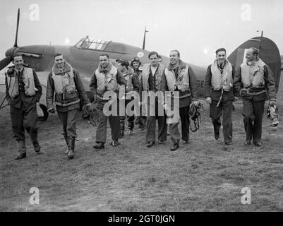 Piloten der RAF-Staffel Nr. 303 (Polen) mit einem ihrer Hawker Hurricanes, Oktober 1940. Von links nach rechts, in der ersten Reihe sind; Pilot Officer Mirosław Ferić, Flugleutnant John A Kent (Kommandant des Fluges A), Flugoffizier Bogdan Grzeszczak, Flugoffizier Jerzy Radomski, Flugoffizier Witold Łokuciewski, Flugoffizier Bogusław Mierzwa (verdeckt von Łokuciewski), Flugoffizier Zdzisław Henneberg, Sergeant Jan Rogowski und Sergeant Eugeniusz Szaposznikow. In der Mitte, hinten in dieser Gruppe, trägt der Flying Officer Jan Zumbach Helm und Brille. Stockfoto