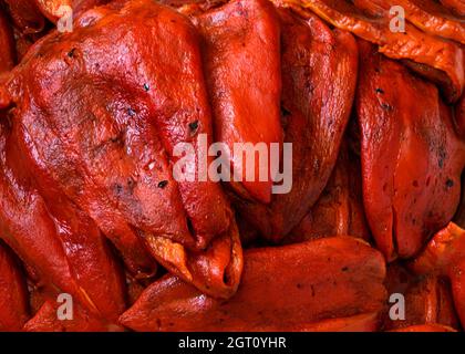 Rote Paprika – frisch geröstet und geschält. Die Ernte von rotem Pfeffer wird natürlich im heimischen Garten angebaut, um für die Familie gesundes Essen zu erhalten. Stockfoto