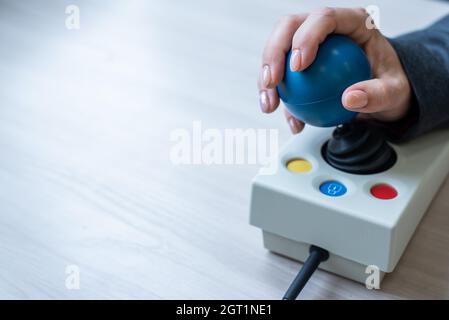 Frau mit zerebraler Lähmung arbeitet an einer spezialisierten Computermaus. Stockfoto