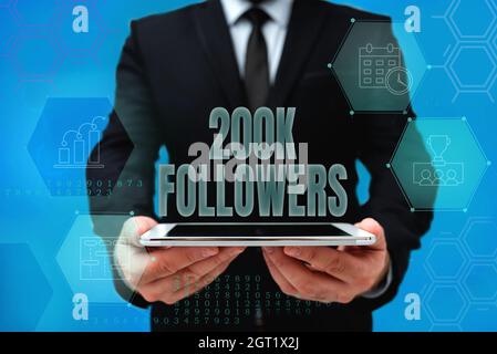 Hand schreiben Zeichen 200K Anhänger. Geschäftsidee Anzahl der Personen, die jemand in Instagram folgt man in Office Uniform Holding Tablet Anzeige Stockfoto