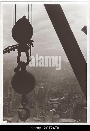 EMPIRE STATE BUILDING NY, NY 1930 - 1931. Allgemeine und detaillierte Ansichten des im Bau befindlichen Empire State Building, in denen Arbeiter verschiedene Aufgaben wie das Positionieren, Schweißen und Nieten von Stahl, das Heben von Materialien und Hilfsgütern sowie das Betreiben und Reparieren von Maschinen zeigen. Es gibt auch eine Vogelperspektive auf Midtown Manhattan, die andere Gebäude zeigt, die im Bau sind. Fotografien von: Hine, Lewis Wickes, 1874-1940 . Stockfoto