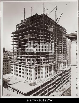 EMPIRE STATE BUILDING NY, NY 1930 - 1931. Allgemeine und detaillierte Ansichten des im Bau befindlichen Empire State Building, in denen Arbeiter verschiedene Aufgaben wie das Positionieren, Schweißen und Nieten von Stahl, das Heben von Materialien und Hilfsgütern sowie das Betreiben und Reparieren von Maschinen zeigen. Es gibt auch eine Vogelperspektive auf Midtown Manhattan, die andere Gebäude zeigt, die im Bau sind. Fotografien von: Hine, Lewis Wickes, 1874-1940 . Stockfoto