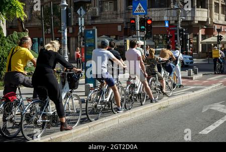 Bukarest, Rumänien - 25. September 2021: Menschen auf dem Fahrrad warten darauf, die Straße auf dem Radweg auf der Victory Avenue in Bukarest, Roman, zu überqueren Stockfoto
