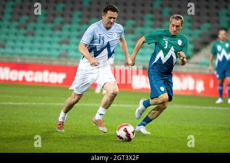 Ljubljana, Slowenien. Oktober 2021. Der ehemalige Kapitän der Nationalmannschaft der Republik Irland, Robbie Keane (L), wird von dem slowenischen Fußballmanager Primoû Gliha (R) bei einem wohltätigen Fußballspiel in Ljubljana herausgefordert. Mitglieder des slowenischen Olympischen Teams und ehemalige slowenische und internationale Fußballstars nahmen an einem traditionellen Wohltätigkeitsfußballspiel in Ljubljana Teil, um Gelder für Sponsoring in Sport zu sammeln, eine Initiative, die jungen Sportlern aus benachteiligten Verhältnissen hilft. Das Spiel wird von Aleksander Ceferin, Präsident der Union of Europe, gesponsert Stockfoto