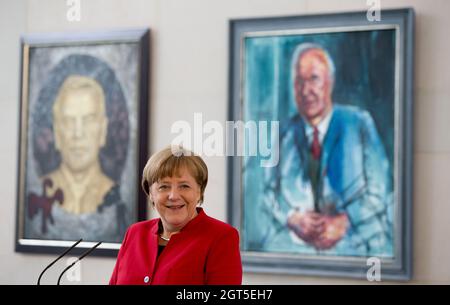 EINGEREICHT - 27. April 2016, Berlin: Bundeskanzlerin Angela Merkel (CDU) spricht beim Girls' Day im Bundeskanzleramt zu den Mädchen. Im Hintergrund hängen Bilder der ehemaligen Kanzler Gerhard Schröder und Helmut Kohl. Im ersten Stock des Bundeskanzleramts befindet sich eine Ahnengalerie mit Porträts aller früheren Regierungschefs der Nachkriegszeit - nur eines fehlt noch: Angela Merkel (CDU). Wird sie sich nach dem Ende ihrer Amtszeit selbst malen lassen? Und wenn ja, von wem? (To dpa 'wird Merkel ihr Porträt für die Galerie der Vorfahren malen lassen?') Foto: Pictu Stockfoto