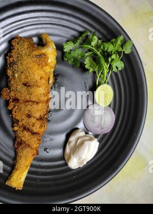 Ganze Fischbraten auf dem Teller serviert. Indische malabar-Stil Zubereitung mit Koriander, Zwiebeln dekoriert. Perfekte proteinreiche Mahlzeit. Nahaufnahme. Stockfoto