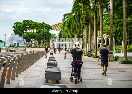 Touristen/Einheimische, die entlang des Singapore River in Richtung Marina Bay Sands fahren. Stockfoto