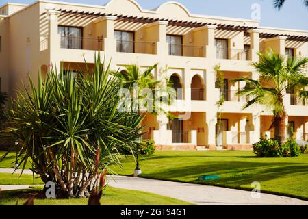 Ferienresort. Luxuriöses ägyptisches Hotel mit Palmen, perfektem grünen Rasen und klarem blauen Himmel. Stockfoto