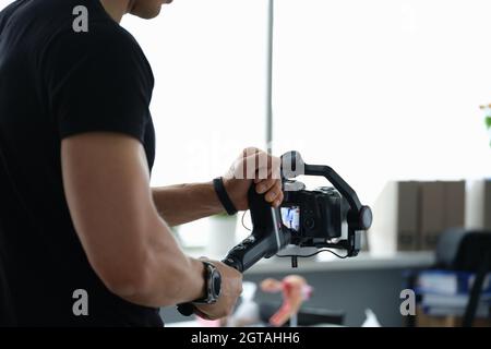 Der Videofilmer hält den Stabilisator mit der Kamera in der Nahaufnahme Stockfoto