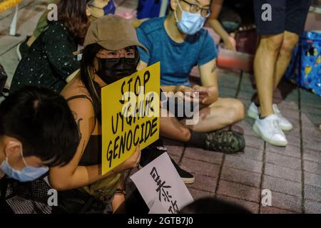 Taipeh, Taiwan. Oktober 2021. Ein Demonstranten sah, wie er am Nationalfeiertag der Volksrepublik China (PRC) in Taipei vor der Legislativkammer ein Schild hielt, das dazu aufrief, den VÖLKERMORD AN DEN UIGUREN zu STOPPEN. Taiwanesische Menschenrechtsorganisationen und Hongkonger Aktivisten veranstalteten in Taipei eine Demonstration, um sich "China zu widersetzen" und zur Einheit und Unterstützung der Menschenrechte zu rufen. Kredit: SOPA Images Limited/Alamy Live Nachrichten Stockfoto