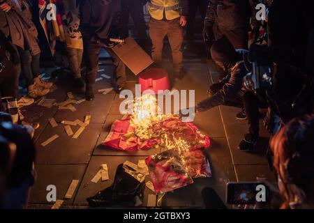 London, Großbritannien. Oktober 2021. Demonstranten feuern eine chinesische Flagge an und zeigen ein Porträt des Präsidenten der Volksrepublik China Xi Jinping und des Führers von Hongkong, Carry Lam, während des Protestes gegen die Repression der Kommunistischen Partei Chinas gegen Hongkong, Tibet, Und Xinjiang am chinesischen Nationalfeiertag vor der chinesischen Botschaft in London.Hongkonger, Tibeter und Uiguren hielten eine gemeinsame Kundgebung und einen marsch in London ab, um gegen die Feier des 72. Jahrestages des Nationalfeiertags der Volksrepublik China zu protestieren. Die Kundgebung begann am Piccadilly Circus und rief die Öffentlichkeit dazu auf, mitzumachen Stockfoto