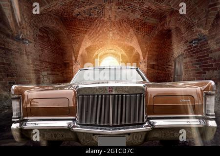 Ford Continental Mark III Straßenkreuzer, Vorderansicht eines amerikanischen klassischen Luxuswagens, zusammengesetzt in einem dunklen Backsteintunnel mit Hintergrundbeleuchtung, Autostandort Schöni Stockfoto