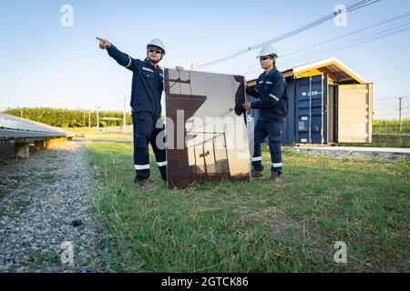 Techniker hebt die Solarzelle, um die beschädigte zu ersetzen, Alternative Energie, um die Energie der Welt zu sparen, Photovoltaikmodul Idee für sauber Stockfoto