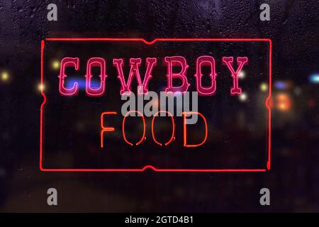 Cowboy CFood Neon-Schild im regnerischen Fenster Stockfoto