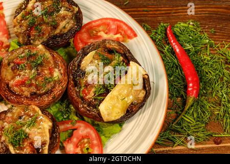 Makroaufnahme von gefüllten Pilzkappen mit Frischkäse und anderen Zutaten, die mit Chili verziert sind Stockfoto