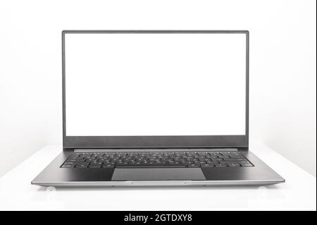 Neuer Laptop aus glänzendem Aluminium mit weißem Bildschirm auf weißem Hintergrund. Laptop mit leerer Frontansicht auf weißem Tischhintergrund. Silbernes Notebook Stockfoto