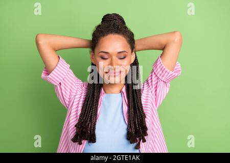 Oben hoch über Winkel Ansicht Foto von dunkler Haut glücklich Frau Hände hinter dem Kopf isoliert auf grünem Hintergrund Stockfoto