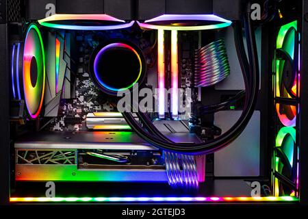 Innenansicht des schwarzen High-End-Gaming-pcs mit farbenfroh beleuchtetem, strahlendem Regenbogen-RGB-LED. Hintergrund des Computer-Power-Hardware- und Technologiekonzepts Stockfoto