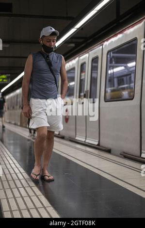 BARCELONA, SPANIEN - 25. Aug 2021: Eine vertikale Aufnahme eines Mannes, der auf dem Bahnsteig der Barcelona Metro in Spanien läuft Stockfoto