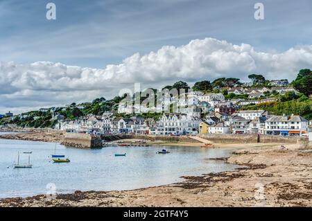 Ein schöner, weitläufiger Blick auf den Sandstrand, den Hafen und einen Teil der kleinen Stadt St. Mawes auf der Halbinsel Roseland, Cornwall. Ein warmer, sonniger Tag. Stockfoto