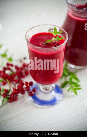 Frisch gepresster dicker natürlicher Saft mit Fruchtfleisch aus reifen roten Viburnum in einer Karaffe Stockfoto