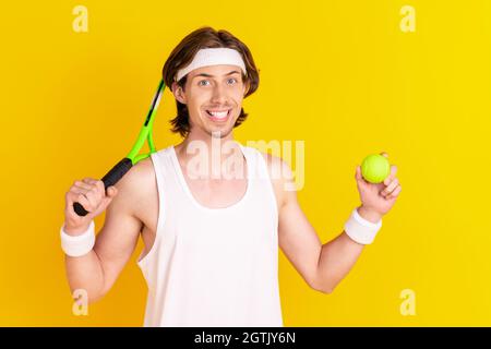 Portrait von attraktiven sportlichen fröhlichen Kerl spielt Tennis isoliert über hellen gelben Hintergrund Stockfoto