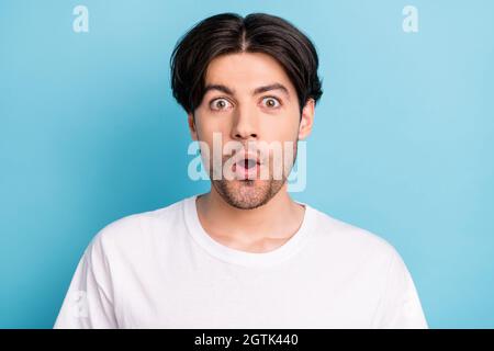 Porträt der attraktiven erstaunt wunderten Kerl plötzliche Nachrichtenreaktion isoliert über lebendige blaue Hintergrund Stockfoto