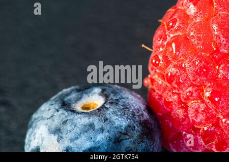 Makrofrucht: Reife Himbeere extreme Nahaufnahme, schwarzer Hintergrund, horizontales Format Stockfoto