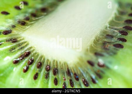 Makrofrucht: Extreme Nahaufnahme einer reifen Kiwi-Frucht, schwarzer Hintergrund, horizontales Format Stockfoto