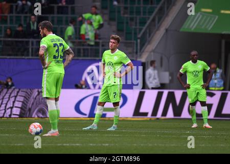 02. Oktober 2021, Niedersachsen, Wolfsburg: Fußball: Bundesliga, VfL Wolfsburg - Borussia Mönchengladbach, Matchday 7 in der Volkswagen Arena. Der Wolfsker Daniel Ginczek (l-r), der Wolfsker Gian-Luca Waldschmidt und der Wolfsker Jerome Roussillon stehen nach dem 1:3-Tor auf dem Feld enttäuscht. Foto: Swen Pförtner/dpa - WICHTIGER HINWEIS: Gemäß den Bestimmungen der DFL Deutsche Fußball Liga und/oder des DFB Deutscher Fußball-Bund ist es untersagt, im Stadion und/oder vom Spiel aufgenommene Fotos in Form von Sequenzbildern und/oder videoähnlichen Fotoserien zu verwenden oder zu verwenden. Stockfoto