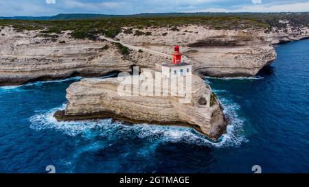 Luftaufnahme des Leuchtturms von La Madonetta in Bonifacio, an der Südspitze der Insel Korsika in Frankreich - Wellen, die auf Kalksteinfelsen krachen Stockfoto