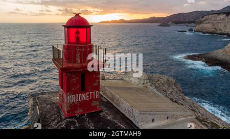 Luftaufnahme des Leuchtturms von La Madonetta in Bonifacio, an der Südspitze der Insel Korsika in Frankreich - Wellen, die auf Kalksteinfelsen krachen Stockfoto