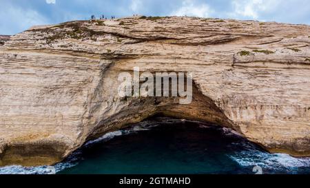 Luftaufnahme des Leuchtturms von La Madonetta in Bonifacio, an der Südspitze der Insel Korsika in Frankreich - Wellen, die auf Kalksteinfelsen krachen Stockfoto